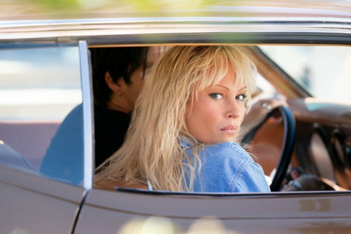 A distraught Pamela (Lily James) looks out a car window while Tommy (Sebastian Stan) drives.