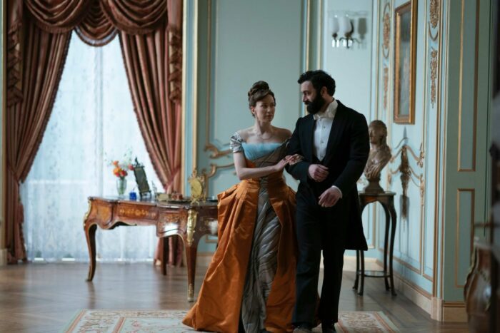 Carrie Coon and Morgan Spector walk arm in arm in The Gilded Age on HBO