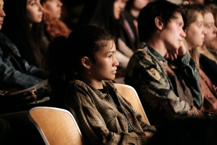 Rue looks on from a theater seat in Euphoria S2E8, the Season 2 finale, All My Life, My Heart Has Yearned for a Thing I Cannot Name