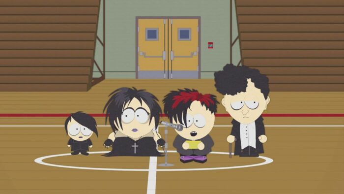 The goth kids at a microphone in the school gymnasium, making an announcement