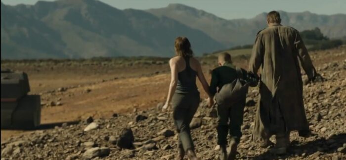 Sue, Paul and Marcus walk through the rocky terrain towards the tank, almost off screen