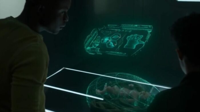 Hunter and Tempest look down on her baby inside the med lab analysis holo