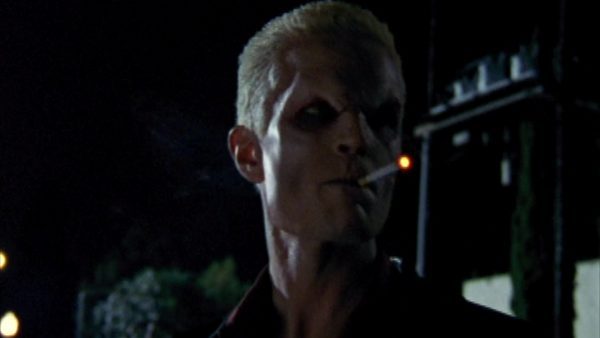 Spike in vamp face smoking a cigarette at night