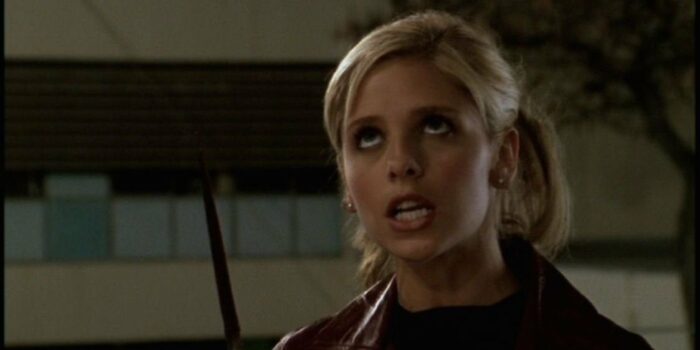 Buffy standing in the darkness holding Faith's knife