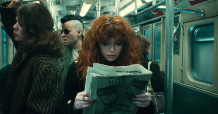 Nadia on the subway looking at a newspaper