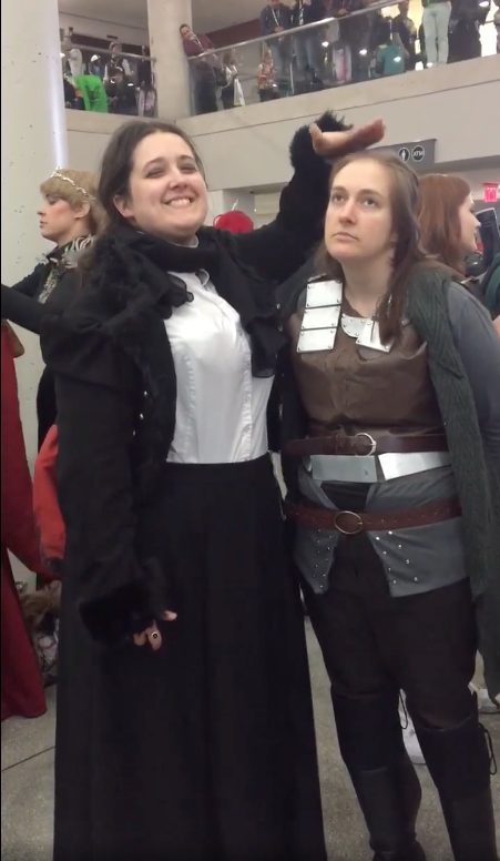 A cosplay of Anne Lister patting the head of a Yara Greyjoy cosplay. 