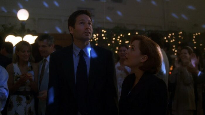 Amused, Mulder and Scully look around at the high school reunion dance