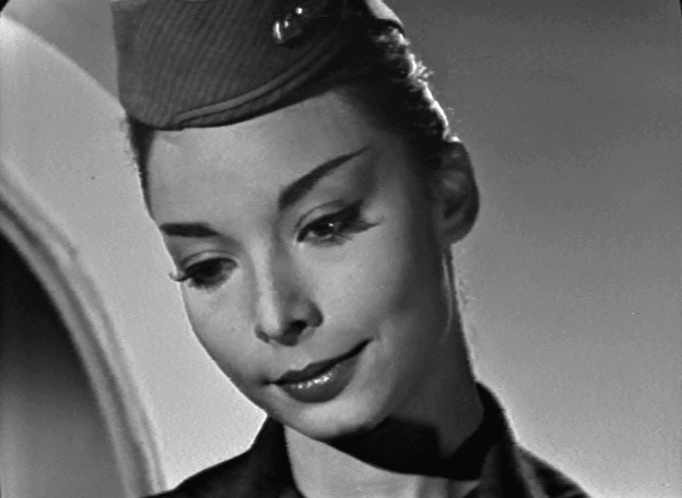 A closeup of the stewardess, identical to the nurse from Liz's nightmare