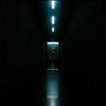 Ms. Casey entering an elevator at the end of a dark hallway in Severance S1E8