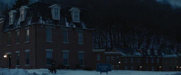 Row houses with a sign that reads Leonora Lake in front of them in Severance S1E8, "What's for Dinner?"