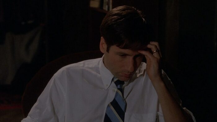 A pre-X-Files Mulder brushes his hair aside, showing off the mysterious wedding band