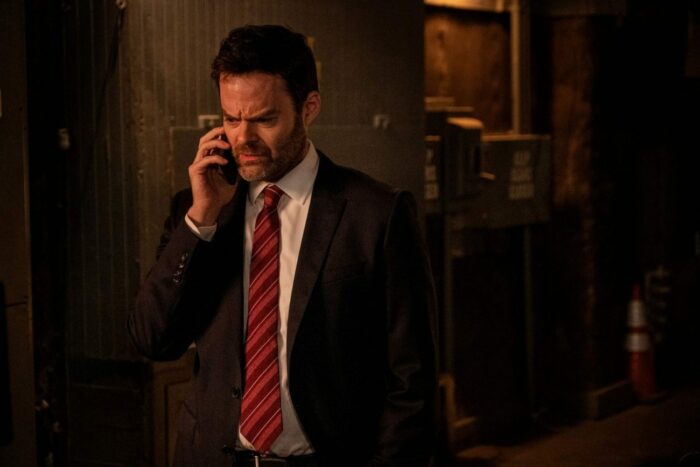 Barry, wearing a suit and tie, with a cellphone to his ear