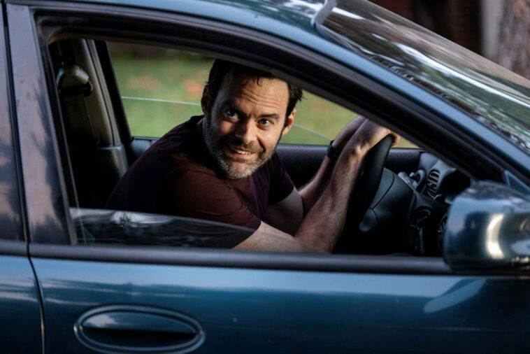 Barry leans over the wheel of a car, looking out the window with a smile in Barry S3E3