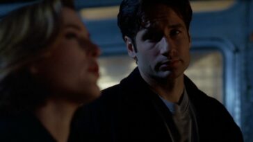 Mulder looks over at Scully, skeptically