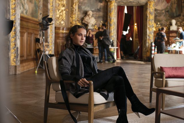 Alicia Vikander as MIra Harberg, seated in a chair in HBO's Irma Vep.