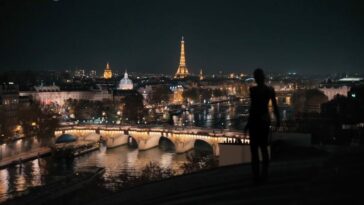 As Irma Vep, Alicia Vikander strides across nighttime Parisian rooftops, the Eiffel Tower in the background.