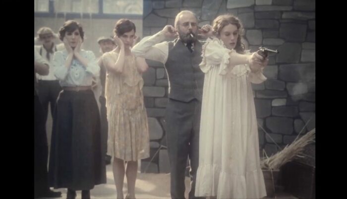 Nora Hamzawi, Alicia Vikander, Vincent Macagine hold heir ears as Lou Lampros fires a gun on the set of Les Vampires,