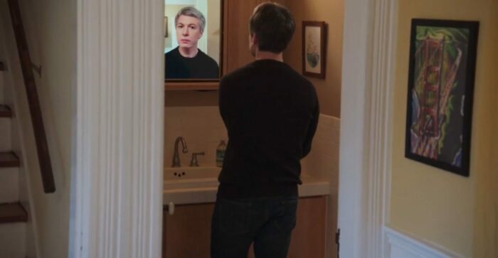 An digitally aged Nathan looks back at Nathan in a bathroom mirror