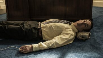 Saul Goodman lies on the floor of his office using the Swing Master
