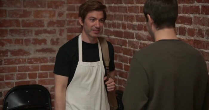 Nathan in an apron pretending to be Thomas talks to Fake Nathan