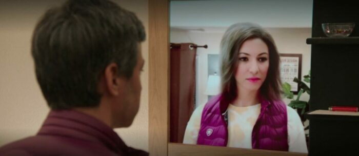 Nathan looks into a mirror with a version of himself as Amber looking back