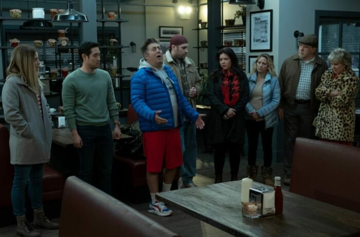 Sam, Neil, Pete, Patty, Allison, and others stand in a restaurant in Kevin Can F**k Himself S2E5