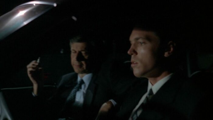 Krycek sits uncomfortably in his car with The Smoking Man