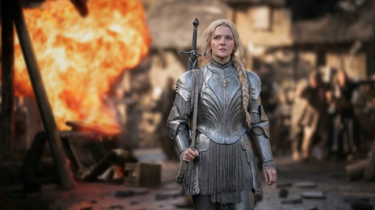 Galadriel in her armor staring ahead as fire rains around her