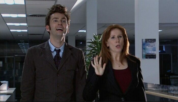 The Doctor and Donna stand in an office looking a bit goofy in "Partners in Crime"