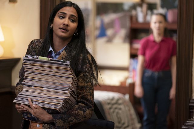The Sex Lives of College Girls season 2 finale - Bela (Amrit Kaur) walking down the dormitory hall with a stack of magazines
