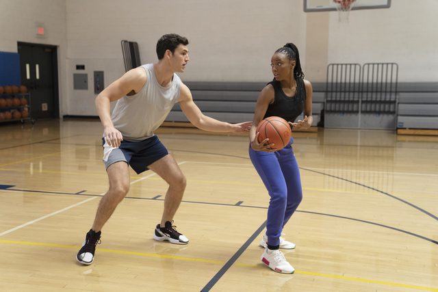 Andrew (Charlie Hall) and Whitney (Alyah Chanelle Scott) on the basketball court playing one on one