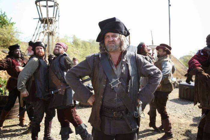 The King of the Pirates (Hugh Bonneville) standing with the pirate crew in the background