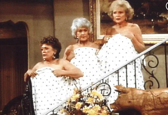 Blanche, Dorothy and Rose on a staircase, covering their nudity with a sheet