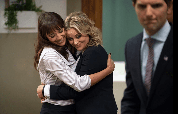 Leslie and Anne hug while Ben stands to the side