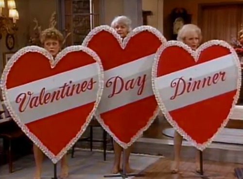 Blanche, Dorothy, and Rose use enormous cardboard hearts that say "Valentine's Day Dinner" to shield their nudity