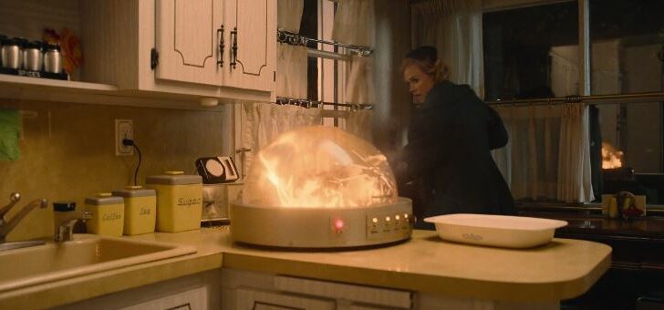 Myrtle sneaks out the door as a futuristic roaster on the counter bursts into flames
