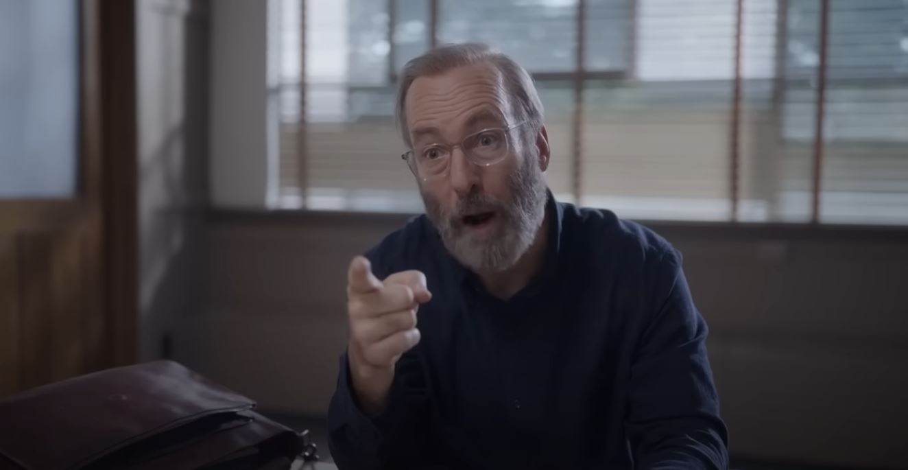 Bob Odenkirk, with glasses and a white beard, points a finger in Lucky Hank