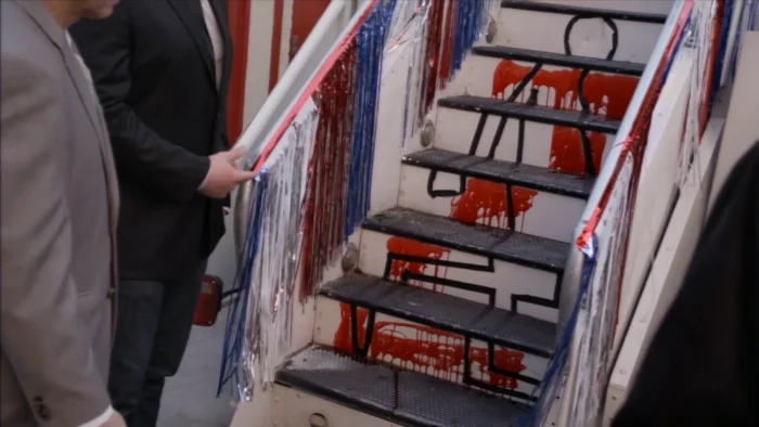 A still of the bloody steps of the Bluth-Austero stair car, with a comically contorted chalk outline drawn to represent how Lucille 2 (Liza Minnelli) landed.