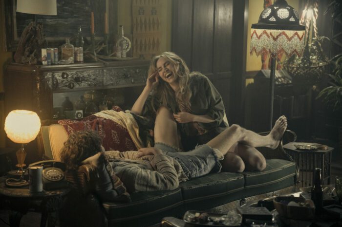 Graham Dunne (Will Harrison) and Karen (Suki Waterhouse) on the couch at The Six house after a romp, laughing