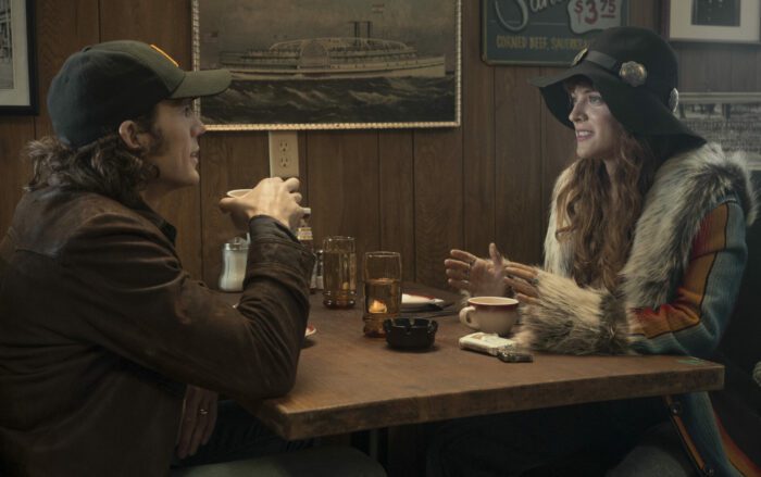 Sam Claflin (Billy Dunne), Riley Keough (Daisy Jones) dressed incognito at a diner