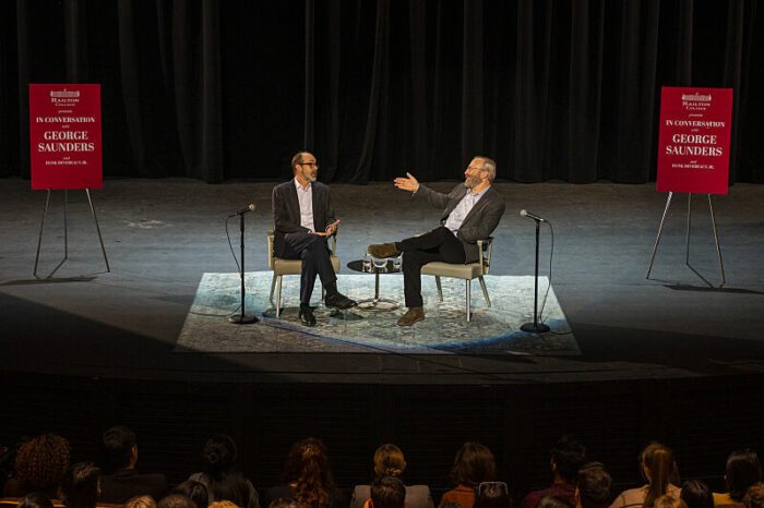 George Saunders and Hank Devereaux on stage at an event