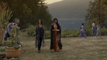 Nat and Lottie walk through a field with trees and a mountain behind them in Yellowjackets Season 2 Episode 2