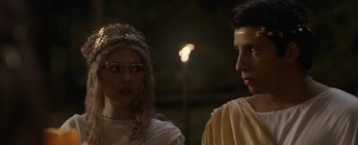 Misty and Travis look over at each other in Roman garb in Yellowjackets S2E2