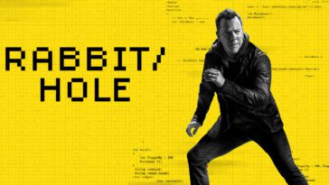 A man runs in a dark leather jacket and pants behind him is a yellow wall with the words Rabbithold