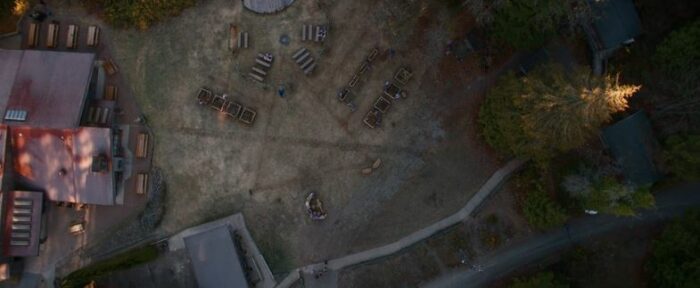 An aerial shot of Lottie's compound, arranged to create the symbol from the wilderness, in Yellowjackets S2E6, "Qui"