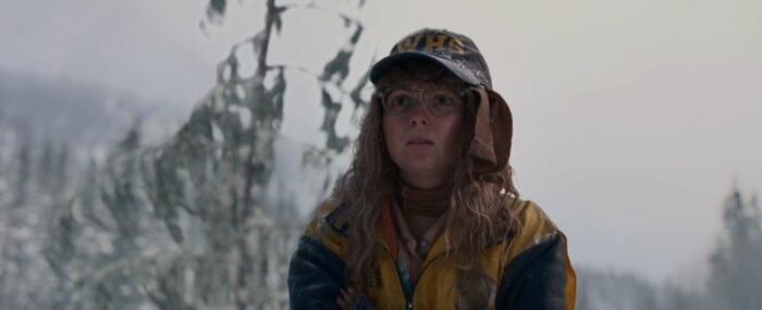 Misty (Samantha Hanratty) stands outside in the snow wearing a hat