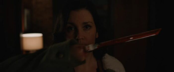 Shauna (Melanie Lynskey) holds a knife hand in front of her face in Yellowjackets S2E8, "It Chooses"