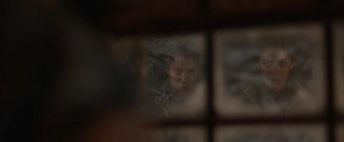 Tai (Jasmin Savoy Brown) looks into a window and sees two reflections of herself that differ from one another