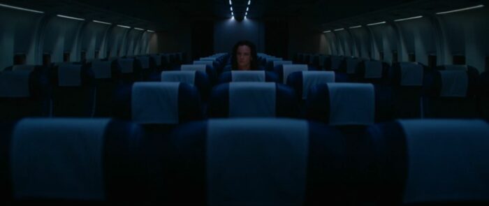 Nat (Juliette Lewis) sits alone in the middle of an empty plane