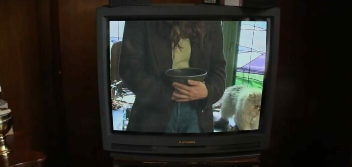 Mrs. Davis S1E4 - Zoom in on a TV, zoomed in on Clara holding the Grail cradled in her hands